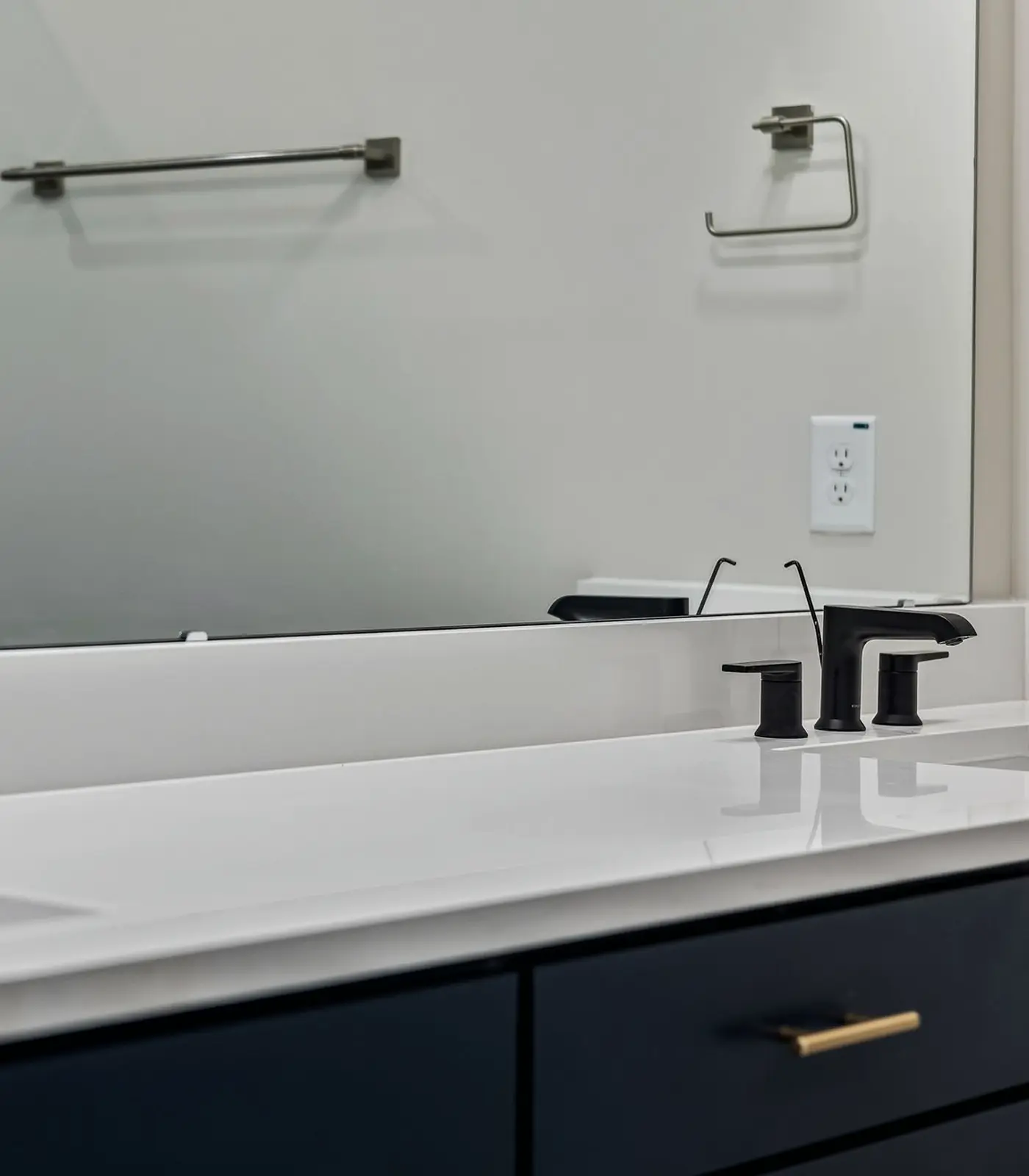 Finished bathroom vanity with two matte black faucets