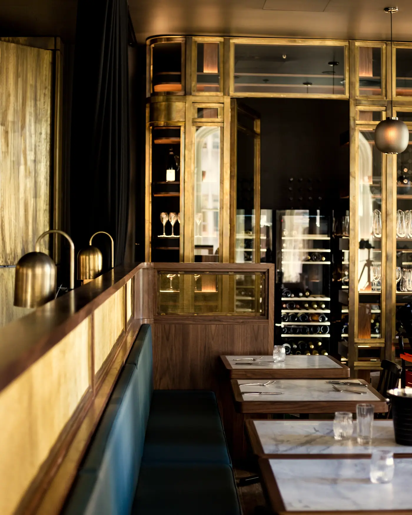 A long banquette and marble tables in the back room
